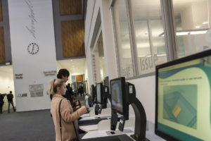 Two students checking books out of the Sydney Jones Library