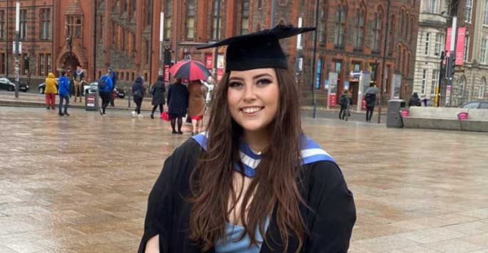 Abbie standing in front of the Victoria Building on her graduation day.