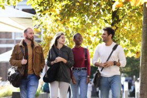 Four postgraduate students walking on campus.