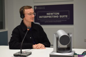 Student using microphone and headphones in Interpreting Suite