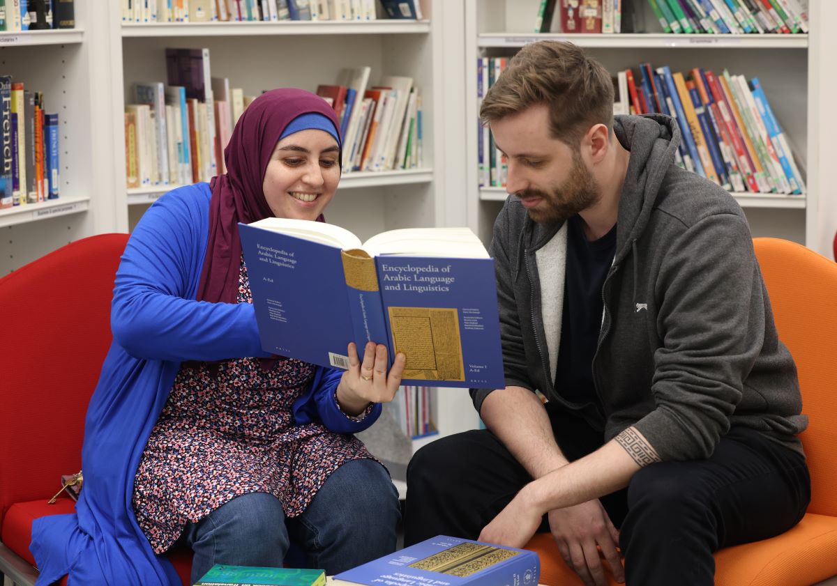 Students looking at a languages text book.