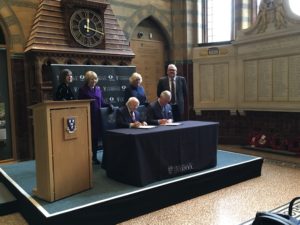 Institute of Irish Studies patrons HRH Prince of Wales and President of Ireland Michael D. Higgins sitting at a desk signing the patronage