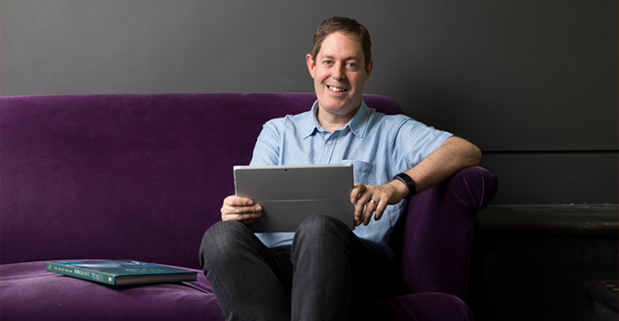 Dr Stuart Penn sitting down with his laptop.