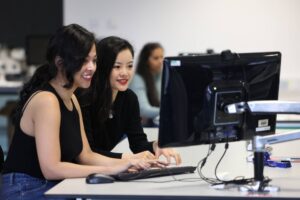 Two students working together at a computer.